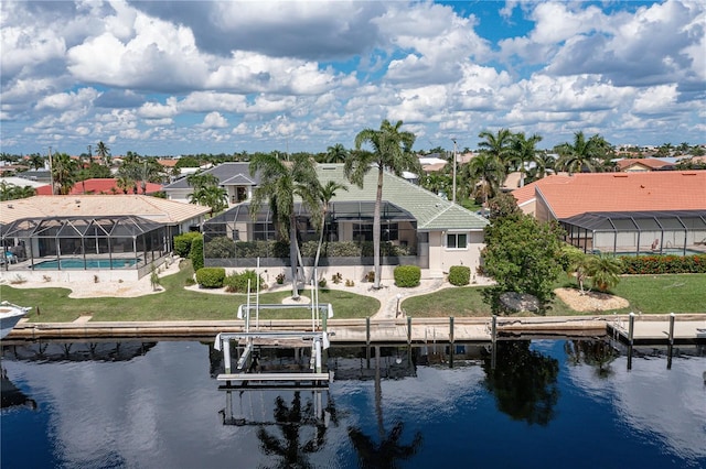 back of house featuring a lanai, a lawn, and a water view