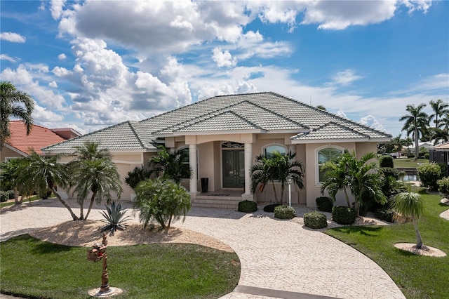 mediterranean / spanish-style house featuring a porch, a front lawn, and a garage