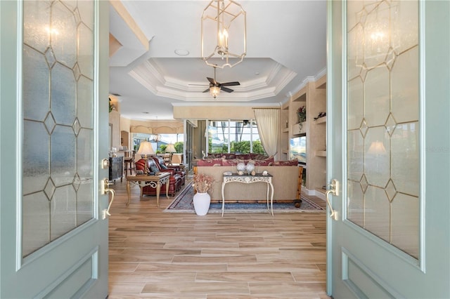 entryway featuring light hardwood / wood-style flooring, a tray ceiling, and ceiling fan