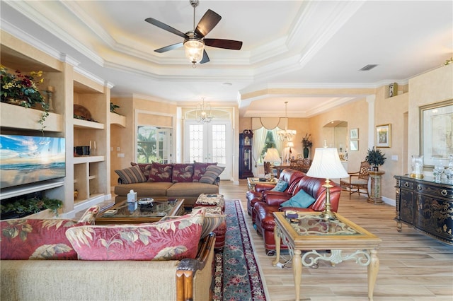 living room featuring a raised ceiling, ornamental molding, and light hardwood / wood-style flooring