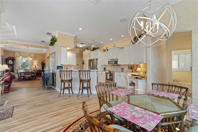 dining room featuring crown molding, a notable chandelier, and light wood-type flooring