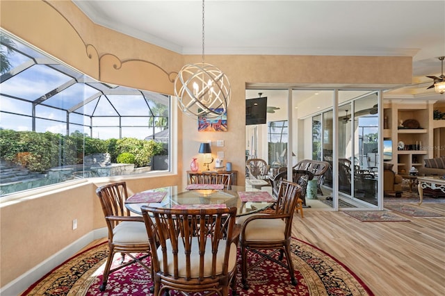 dining room featuring crown molding, ceiling fan with notable chandelier, and hardwood / wood-style floors