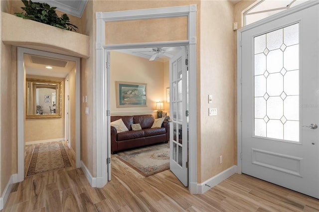 entryway featuring light hardwood / wood-style flooring, ornamental molding, and ceiling fan