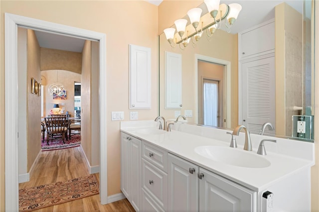 bathroom featuring vanity, hardwood / wood-style floors, and a chandelier