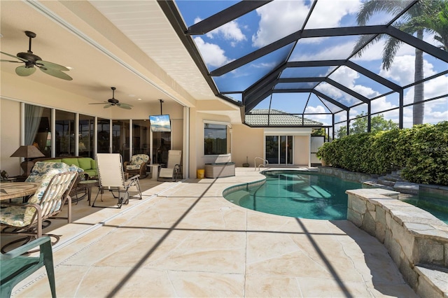 view of swimming pool featuring a patio area, glass enclosure, and ceiling fan