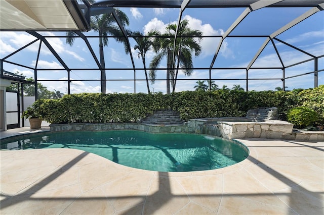 view of pool with a patio, a lanai, and pool water feature