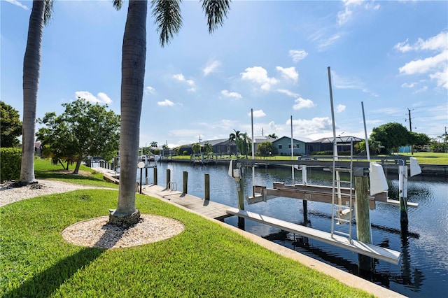 view of dock with a yard and a water view