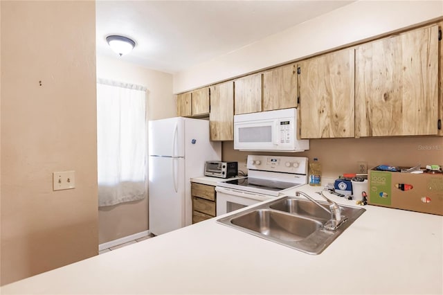 kitchen featuring white appliances, sink, and light brown cabinetry