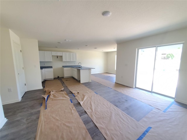 kitchen featuring a center island with sink, white cabinetry, and sink