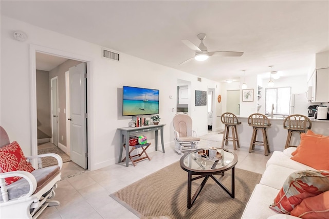 living room with ceiling fan and light tile patterned floors