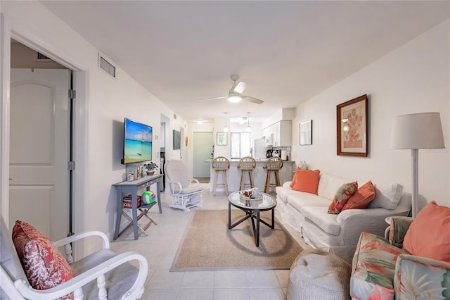 tiled living room with ceiling fan