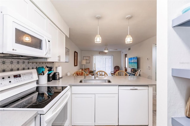 kitchen featuring white appliances, white cabinets, and kitchen peninsula