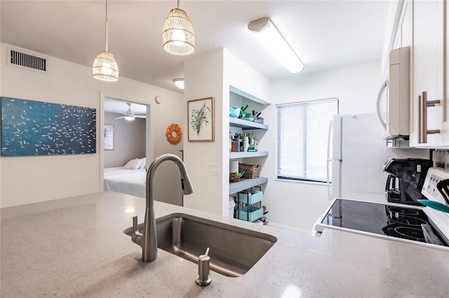 kitchen featuring pendant lighting, sink, range, and ceiling fan