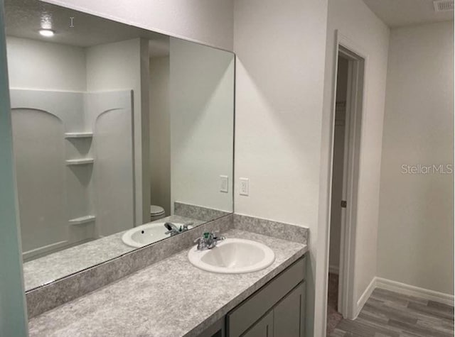 bathroom featuring hardwood / wood-style floors, vanity, and toilet