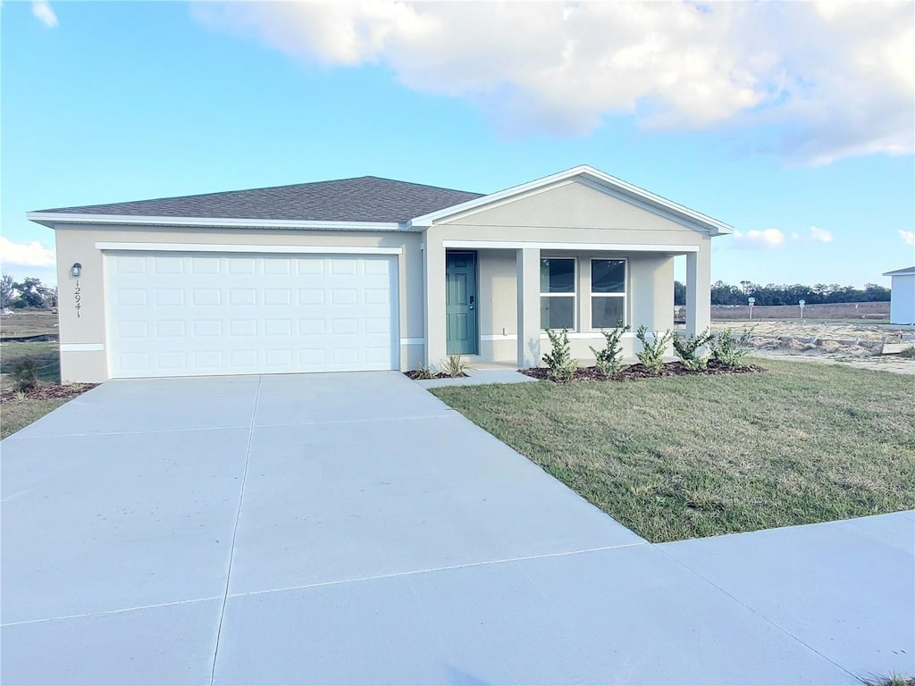 ranch-style home featuring a front lawn and a garage