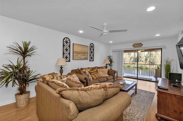 living room featuring ceiling fan and light wood-type flooring