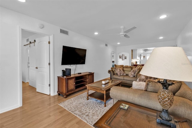 living room with ceiling fan and light hardwood / wood-style floors