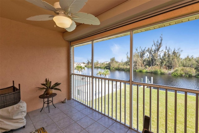 sunroom / solarium featuring a water view and ceiling fan