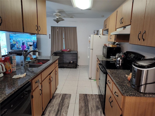 kitchen featuring ceiling fan, dark stone countertops, light tile patterned flooring, black appliances, and sink