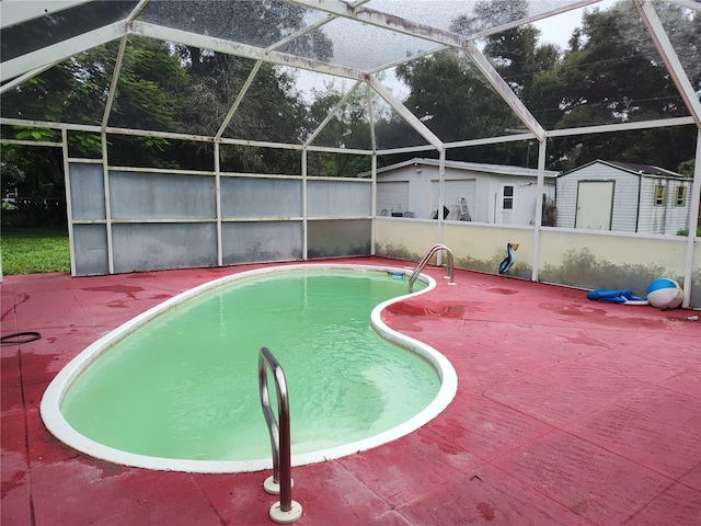 view of pool with a patio, a storage shed, and a lanai