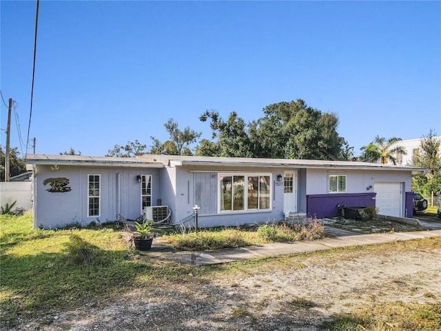 ranch-style house with central AC unit and a garage