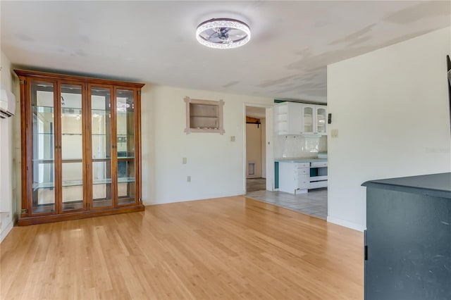 unfurnished living room featuring light hardwood / wood-style flooring and an AC wall unit