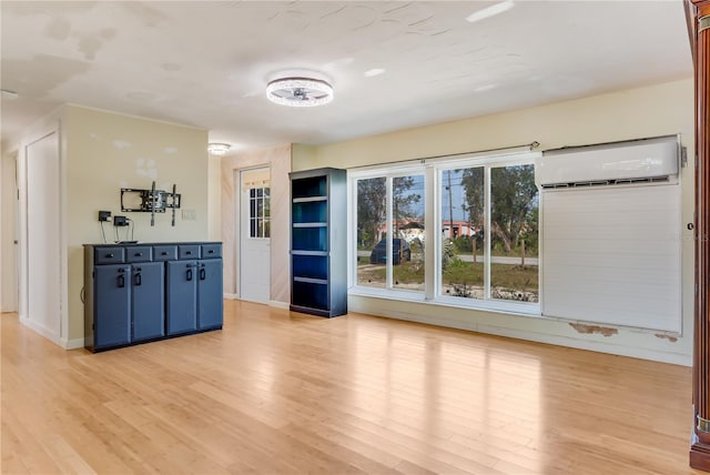 interior space with an AC wall unit and hardwood / wood-style floors