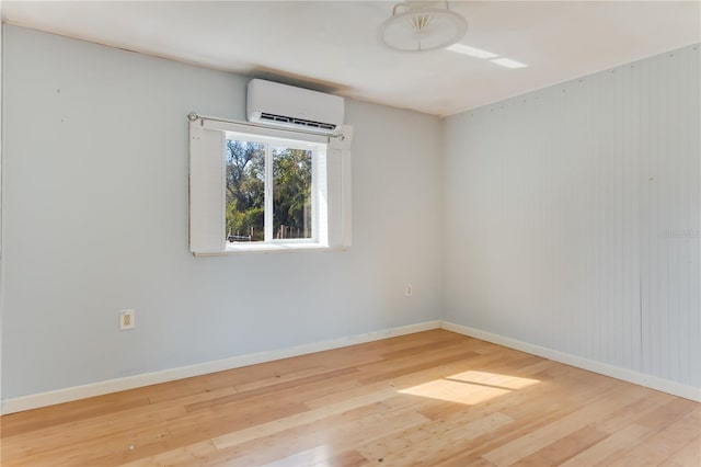 spare room with wood-type flooring and a wall unit AC