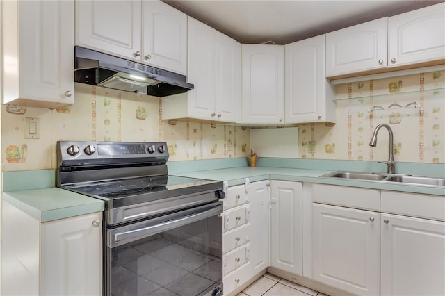 kitchen featuring white cabinets, light tile patterned flooring, sink, and stainless steel range with electric cooktop