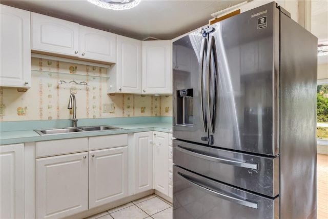 kitchen featuring white cabinetry, sink, stainless steel fridge, and light tile patterned flooring