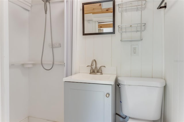 bathroom with vanity, a shower, and toilet