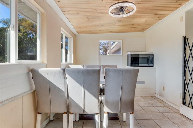 dining room featuring light tile patterned flooring and wood ceiling