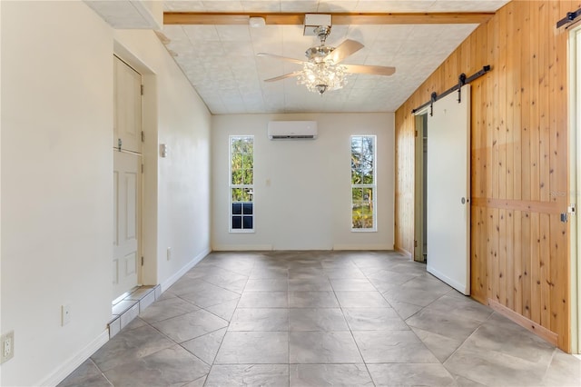 unfurnished room with a wall unit AC, a barn door, ceiling fan, and wood walls