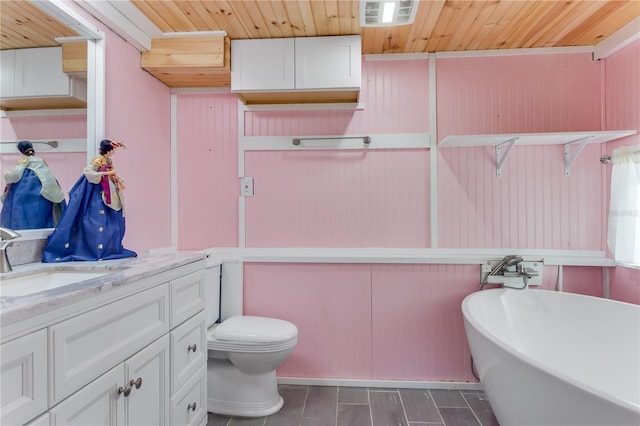 bathroom with vanity, a tub to relax in, and toilet