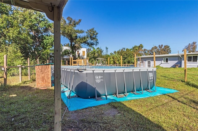 view of swimming pool featuring a yard