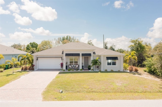 view of front of property featuring covered porch, a garage, and a front yard