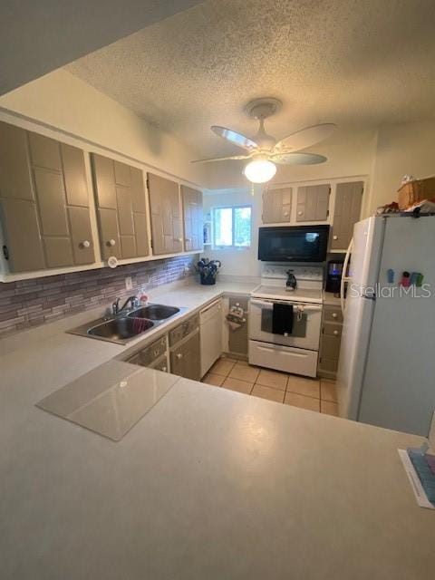 kitchen with backsplash, white appliances, sink, and a textured ceiling