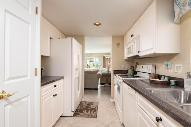 kitchen with white cabinets, white appliances, light tile patterned floors, and sink