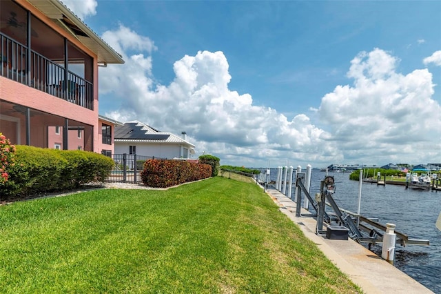 dock area with a lawn and a water view