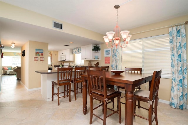 dining room with light tile patterned floors and a notable chandelier