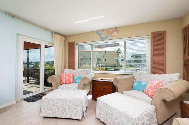 living area with light hardwood / wood-style floors and a healthy amount of sunlight