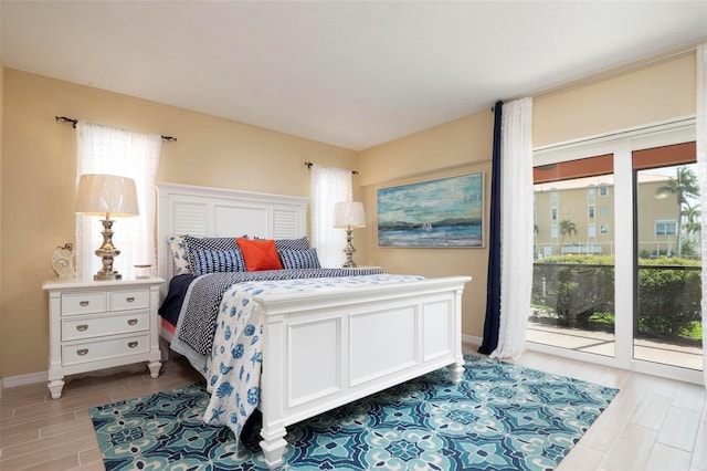 bedroom with light wood-type flooring and access to outside