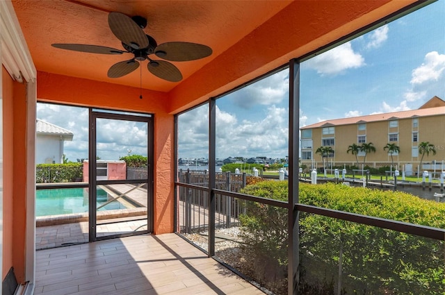 unfurnished sunroom with ceiling fan