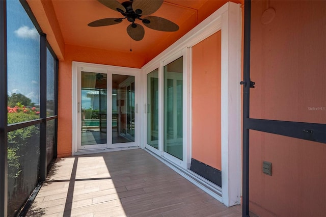 unfurnished sunroom with ceiling fan