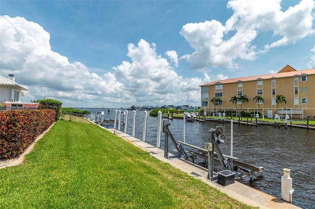 view of dock with a water view and a lawn