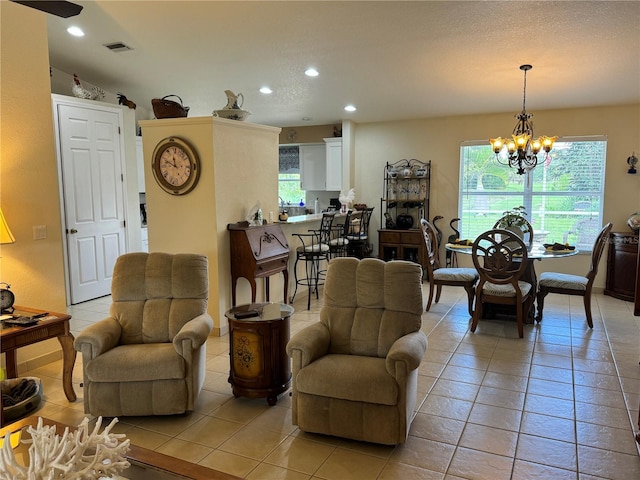 living room with light tile patterned flooring, vaulted ceiling, and an inviting chandelier