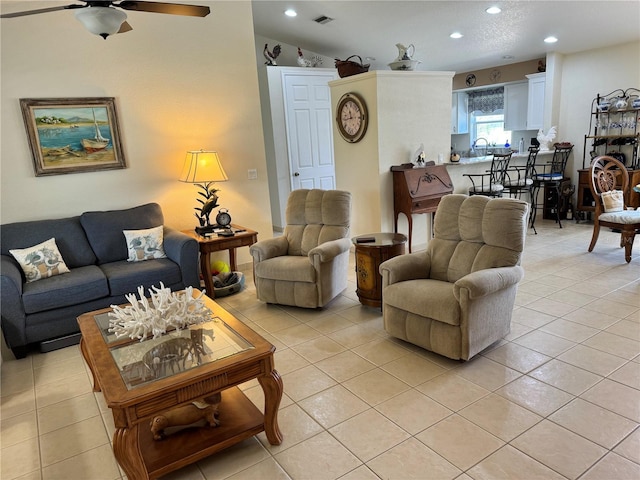 tiled living room with sink, ceiling fan, and vaulted ceiling