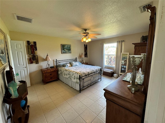 tiled bedroom with a textured ceiling and ceiling fan