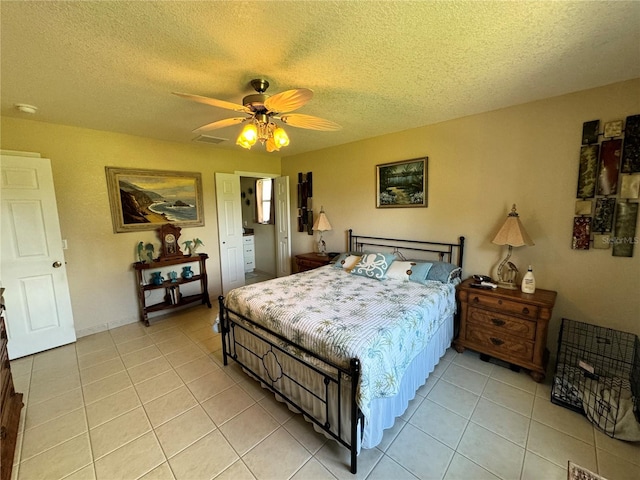 bedroom with ceiling fan, light tile patterned floors, and a textured ceiling