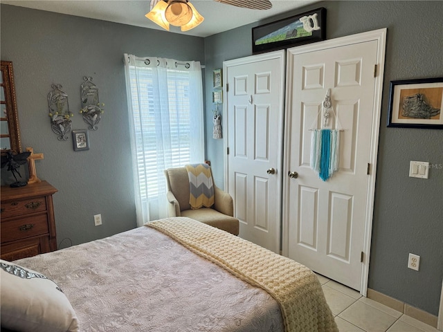 tiled bedroom featuring ceiling fan